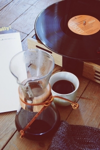 a record playing on the ground with coffee next to it